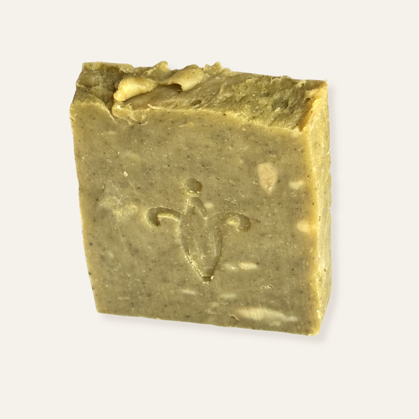 Block of green olive leaf soap with a logo design on a white background. Kemiskhan Atelier