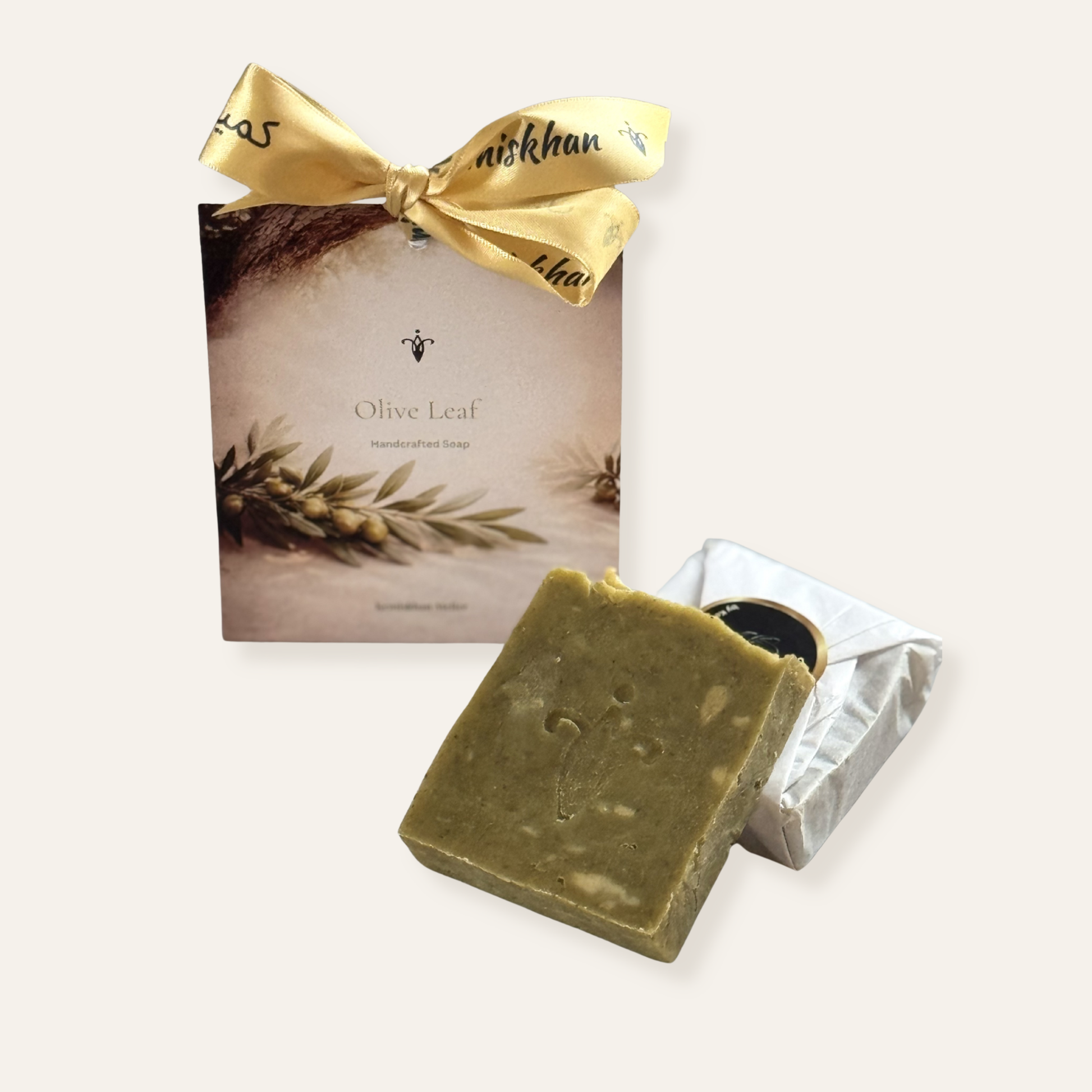 Olive leaf soap with a gold bow and packaging on a white background