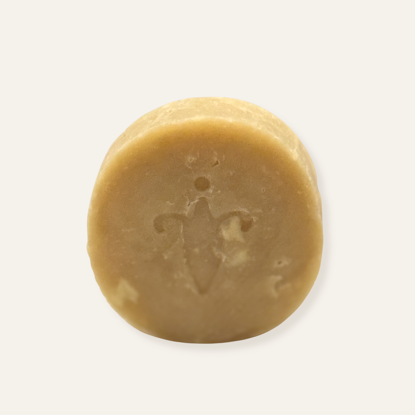 Round beige bar of soap with a brand logo on a white background