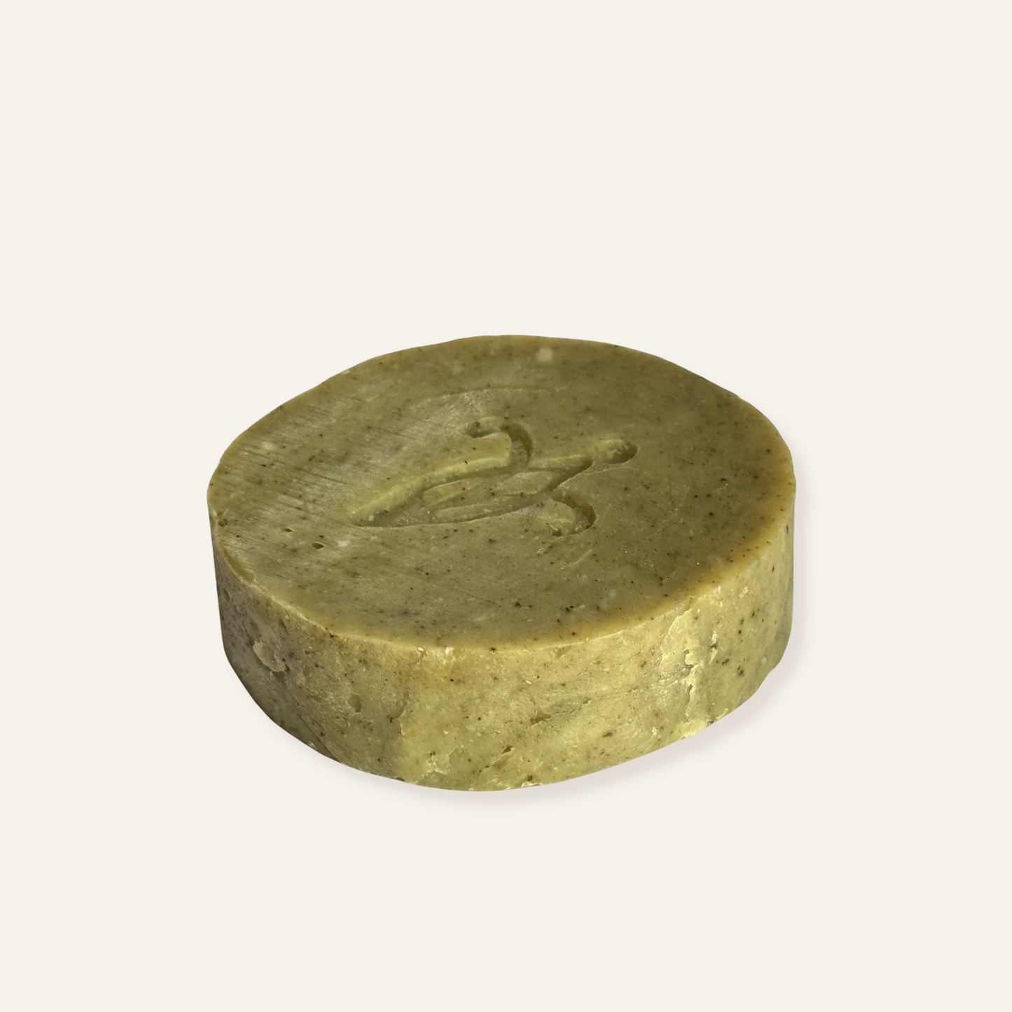 Round green olive soap bar on a white background. Kemiskhan Atelier Natural Gifts